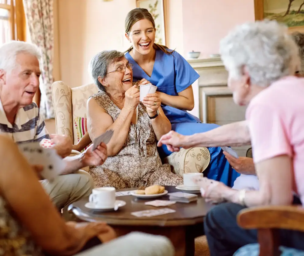 The suspense keeps the game exciting. Shot of a group of happy seniors playing a card game in their retirement home while a nurse watches